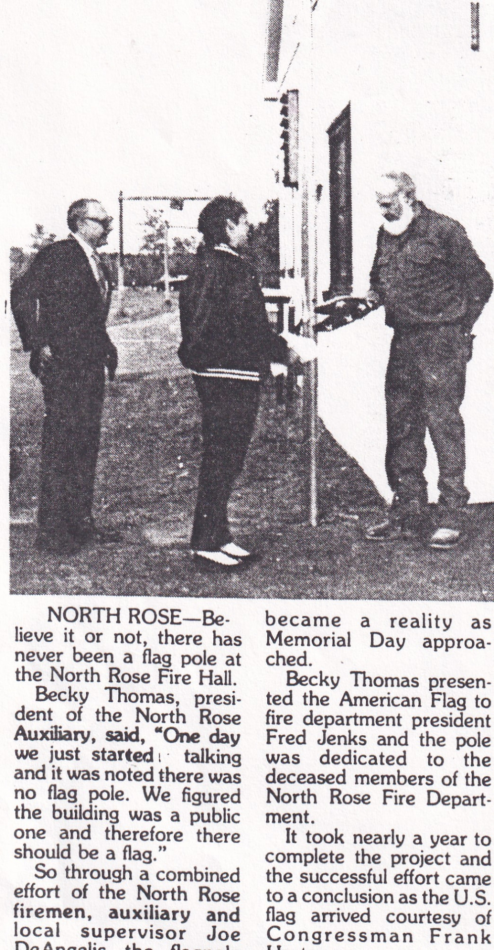 Flag pole dedication at the North Rose Fire Hall — Auxiliary president Becky Thomas presents the American flag to department president Fred Jenks, dedicated to the deceased members of the department, 1987