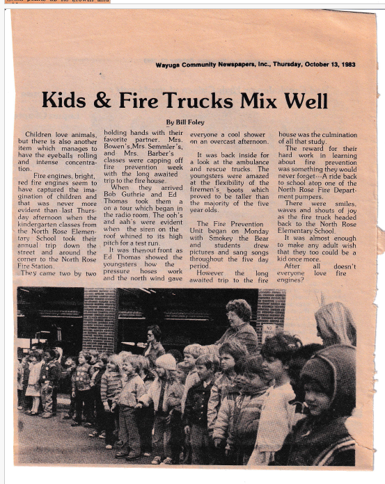 “Kids & Fire Trucks Mix Well” by Bill Foley — kindergarten classes tour the fire house during Fire Prevention Week with Bob Guthrie and Ed Thomas, Wayuga Community Newspapers, 13 October 1983